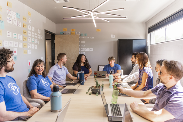 Smith Performance Center team from a different angle, actively discussing patient care and treatment strategies around a table, showcasing their collaborative approach to physical therapy and rehabilitation