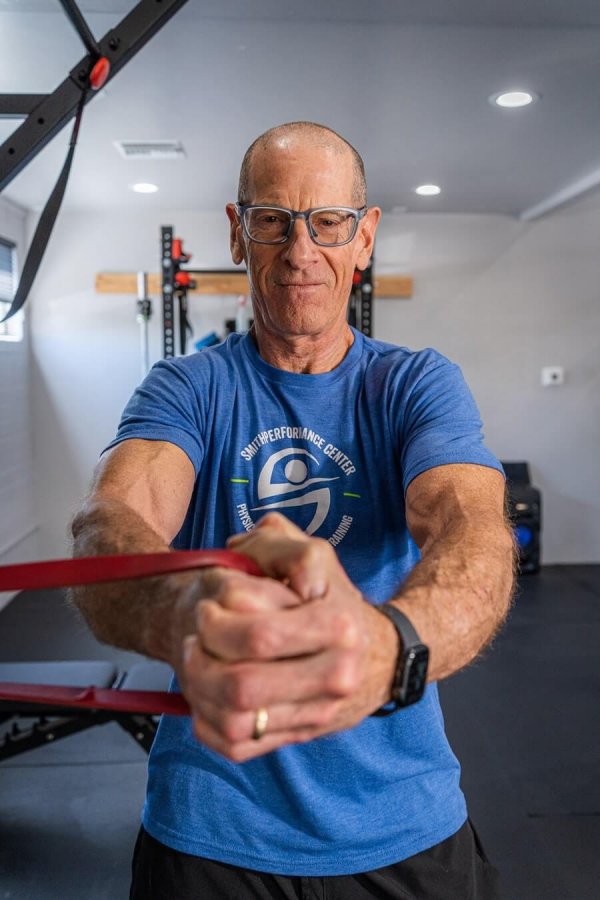 Spencer Roberts, strength coach, performing the Pallof Press at Smith Performance Center, focusing on core stability and anti-rotation strength.