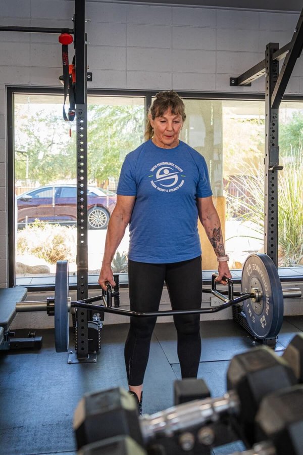Ursula Nelson, strength coach, performing a deadlift at Smith Performance Center, demonstrating proper form and strength training technique.